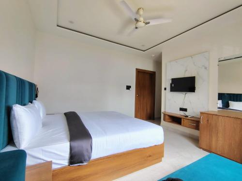 a bedroom with a bed with a ceiling fan at Hotel Gurukripa in Ujjain