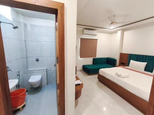 a bedroom with a bed and a bathroom with a shower at Hotel Gurukripa in Ujjain