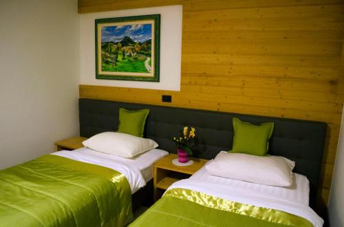 2 camas en una habitación con verde y blanco en Guest House Gostišče Jutriša en Rogatec