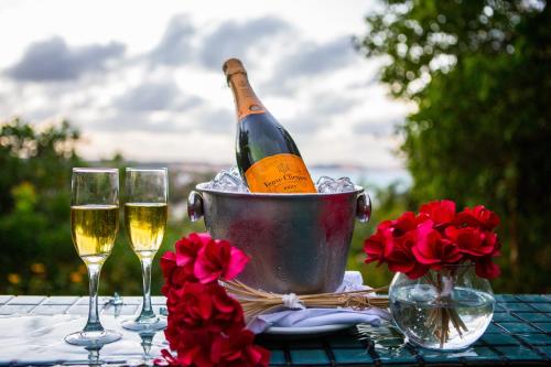a bottle of champagne in a bucket on a table with glasses at Hotel Sombra e Água Fresca in Pipa