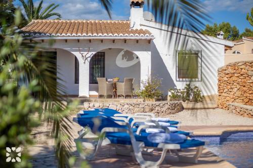 a group of blue tables and chairs in front of a house at Villa Ananas by Abahana Villas in Moraira