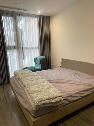 a bedroom with a bed and a blue chair at Dulichxanh3026 in Gia Lâm Pho