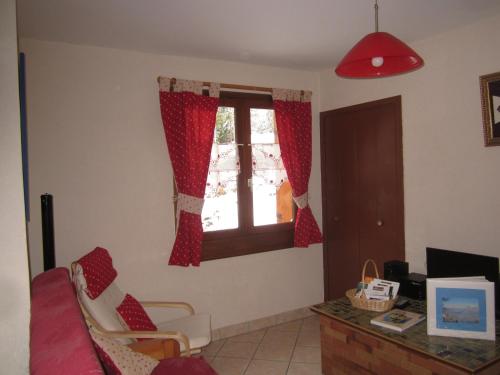 Chalet Yarelle في آلوفارْ: غرفة معيشة بها نافذة بستائر حمراء