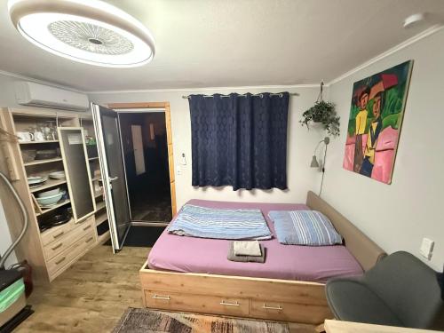 a bedroom with a bed with purple sheets and a window at Tiny House Black Pearl in Tettnang