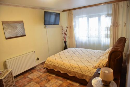 a bedroom with a bed and a television in it at Glow Sahara in Focşani