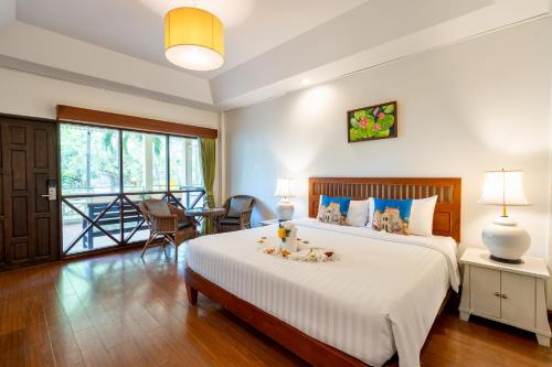 a bedroom with a bed and a table with chairs at Natural Park Resort Pattaya in Jomtien Beach