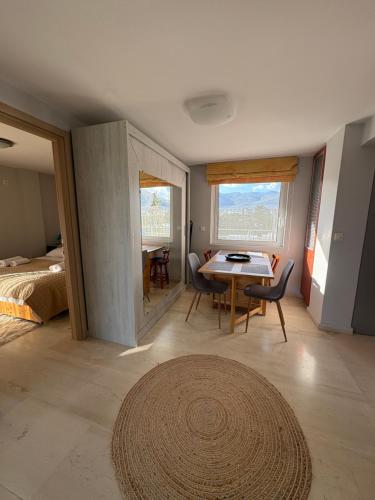 a room with a bed and a table and chairs at HalCyon-On the blue in Nea Makri