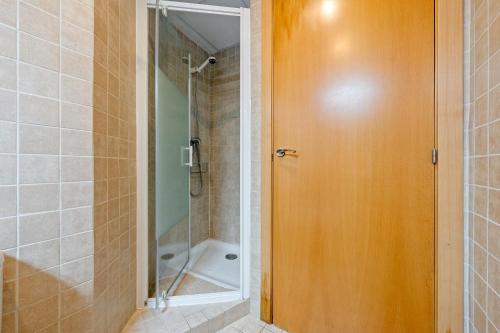 a bathroom with a shower and a wooden door at Portal del Carro 7 Junto a la Catedral in Tarragona