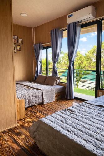 a bedroom with two beds and a large window at Đại Ngàn Homestay in Kon Von Kla