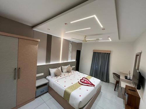 a bedroom with a bed and a desk and a television at Bumblebee Pool Villa Munnar in Anachal