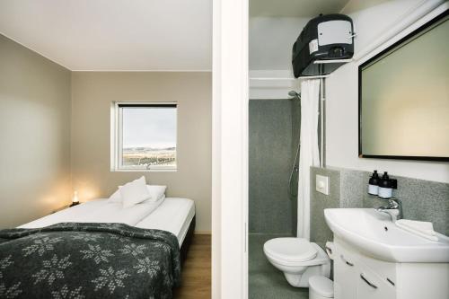 a small bathroom with a bed and a sink at The Highland Center Hrauneyjar in Sprengisandur