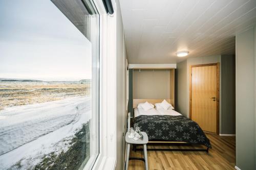 a bedroom with a bed and a view of the ocean at The Highland Center Hrauneyjar in Sprengisandur