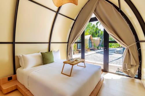 a bedroom with a bed with a large window at Nadi Glamping Suites, Auto-City in Perai