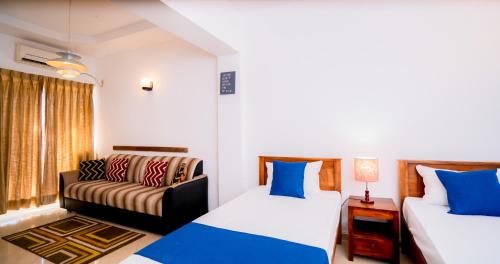 a living room with two beds and a couch at Crystal Sand Mount Lavinia in Mount Lavinia