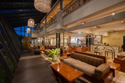 a lobby with couches and tables in a building at Natural Park Resort Pattaya in Jomtien Beach