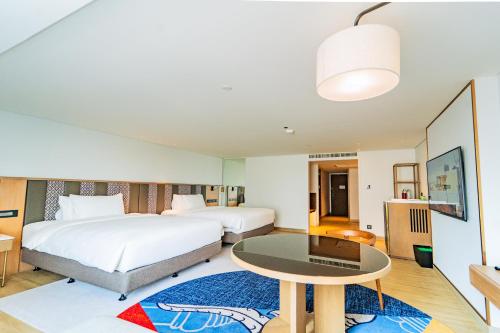 a hotel room with two beds and a table at Montien Hotel Surawong Bangkok in Bangkok