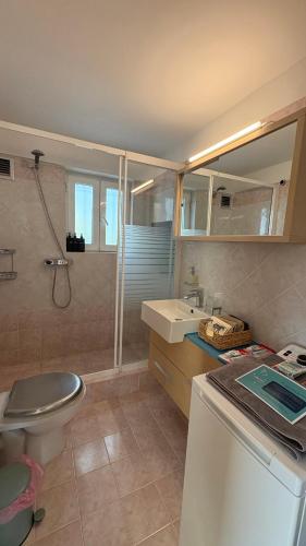 a bathroom with a toilet a sink and a shower at HalCyon-On the blue in Nea Makri