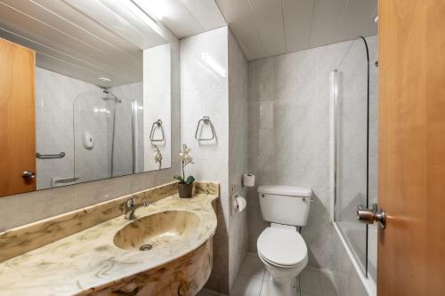 a bathroom with a sink and a toilet and a shower at Antigoni Hotel in Protaras