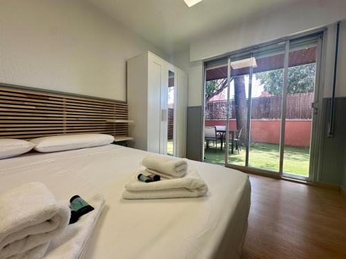 a bedroom with a bed with towels on it at Incredible house with garden in Madrid