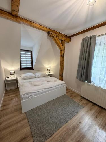 a bedroom with a white bed and a window at Domek Ostoja Energylandia Zator Graboszyce in Graboszyce