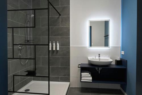 a bathroom with a shower and a sink and a tub at Four Points Flex by Sheraton Östringen in Östringen