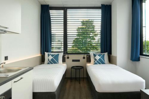 two beds in a room with a christmas tree in the window at Four Points Flex by Sheraton Östringen in Östringen