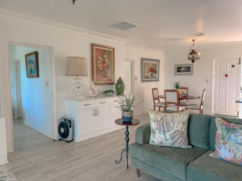 a living room with a green couch and a table at The Estuary Country Estate, Villa "Once Upon A Tide" in Port Edward