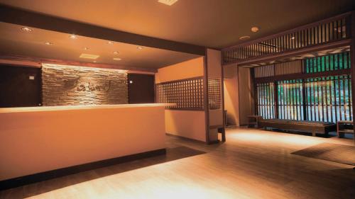 a hotel lobby with a bar and a window at Aizu Higashiyama Onsen "Tsuki no Akari" self-service INN in Aizuwakamatsu