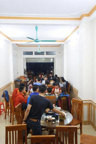 a group of people sitting at tables in a restaurant at Kiên Bin Đồng Văn Hotel in Dồng Văn
