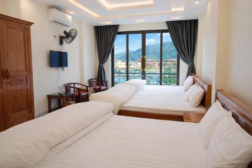 a hotel room with four beds and a window at Kiên Bin Đồng Văn Hotel in Dồng Văn