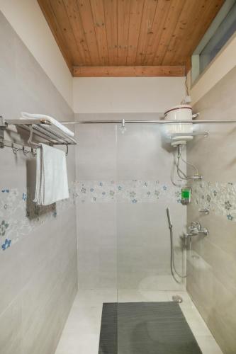 a bathroom with a shower with a glass door at Hotel Sarai Bharatgarh in Nohan