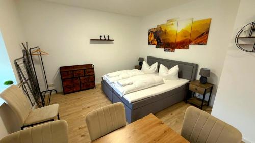 a bedroom with a bed and a table and chairs at Bitterfeld Apartment modern & gemütlich in Holzweißig
