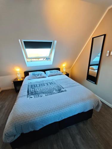 a bedroom with a large bed with a window at Vakantiewoning aan Zee in Zoutelande