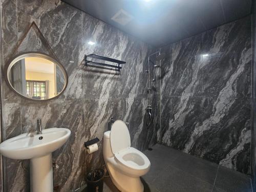 a bathroom with a sink and a toilet and a mirror at Island Sea One Resort in Panglao Island