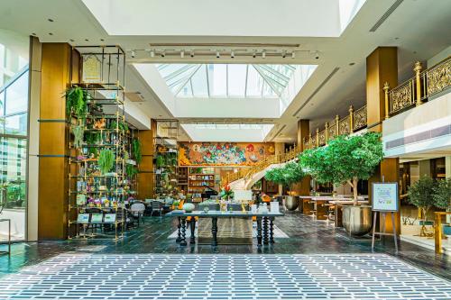 a view of a shopping mall with tables and plants at Montien Hotel Surawong Bangkok in Bangkok