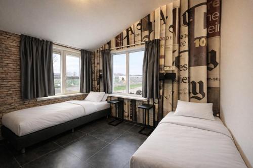 two beds in a room with two windows at Group accommodation De Beemster with Sauna | 14 persons in West-Graftdijk