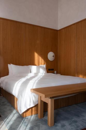 a bedroom with a large bed with a wooden wall at Bellhop Tbilisi in Tbilisi City