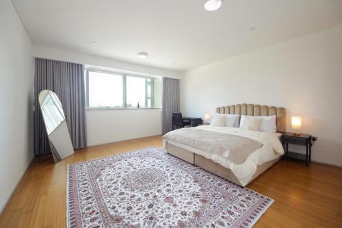 a bedroom with a large bed and a rug at Silk Valley - Al Raha Luxury 1B with Direct Beach Access in Abu Dhabi