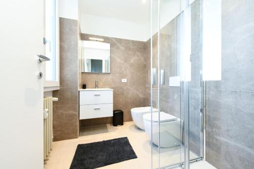 a bathroom with a toilet and a glass shower at Desenzanoloft Garda Golden Sunrise official partner Homes and Villas By Marriott Bonvoy in Desenzano del Garda