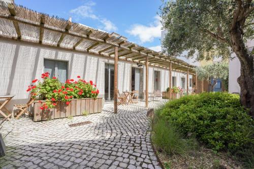 a patio with flowers in wooden planters next to a building at Charming design house in Montijo with garden - 41 in Montijo