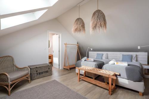 a bedroom with two beds and a couch and a table at Charming design house in Montijo with garden - 41 in Montijo