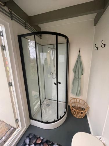 a bathroom with a glass shower in a room at Op zoek naar een leuke overnachting Te huur Prachtig Tiny House De Hutte in Siddeburen
