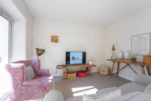 a living room with a couch and a tv at Charming design house in Montijo with garden - 41 in Montijo