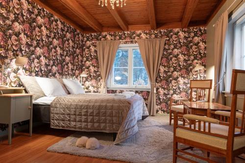 a bedroom with a bed and floral wallpaper at Villa Metsänvartija in Vihtijärvi