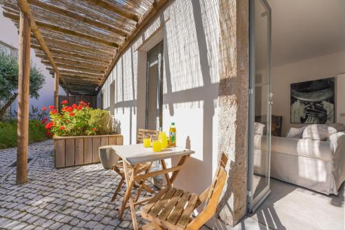 a patio with a table and chairs and a bed at Charming design house in Montijo with garden - 43 in Montijo
