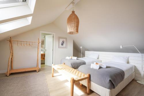 a bedroom with two beds and a bench in it at Charming design house in Montijo with garden - 43 in Montijo