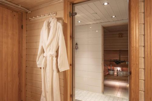 a robe hanging on a wall in a bathroom at Villa Metsänvartija in Vihtijärvi