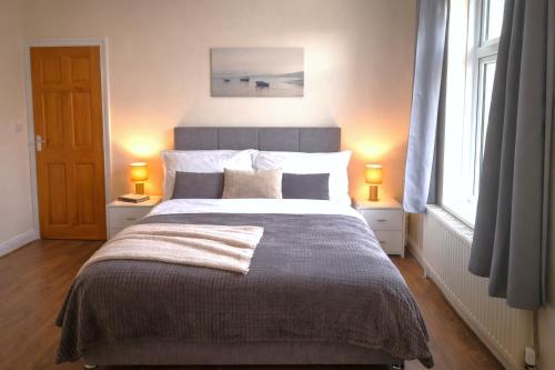 a bedroom with a large bed with two lamps at Evo C - 2 Bed Apartment 2 Min Walk to Station - longer stays available in Gravesend