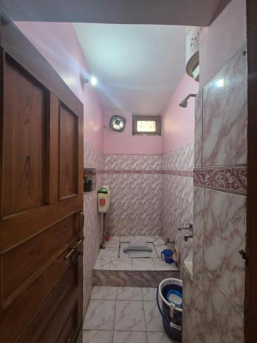 a bathroom with a toilet and a wooden door at Triveni Bliss in Prayagraj