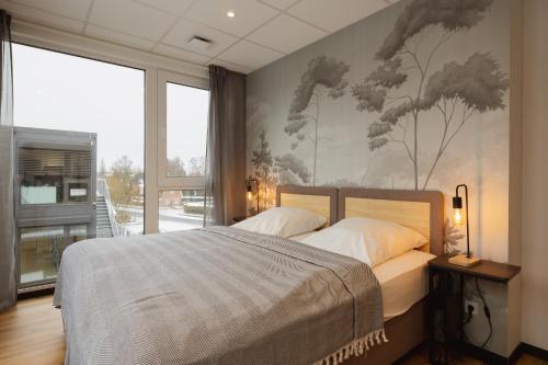 a bedroom with a bed with a painting on the wall at HYGGE HOMES Apartment 'Scandi Sunset' in Winsen